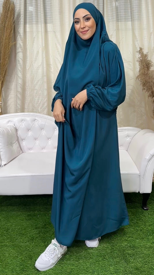 Abito preghiera, donna islamica, scarpe bianche, sorriso, vestito ciano, divano bianco, vestito lungo Hijab Paradise