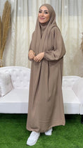 Load image into Gallery viewer, Abito preghiera, donna islamica, scarpe bianche, sorriso, vestito beaje scuro, divano bianco, vestito lungo Hijab Paradise
